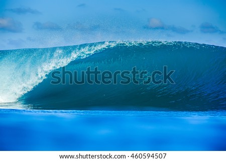 Shorebreak Big ocean wave in daylight. Beautiful sky with clouds. Sea Water surface for surfing sport front view . Nobody on picture. Vibrant bright tropical colorful image.