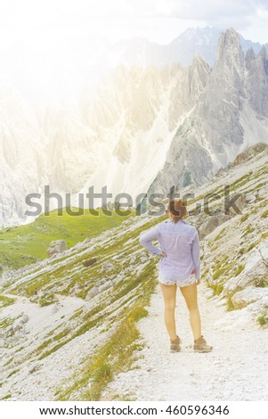 Woman hiker lie have a rest on a mountains. Peaks like a background. Sunny day.Trekking.Lens flare. Successful backpacker enjoy a view