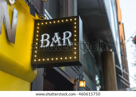 Vintage bar sign on a city street storefront.