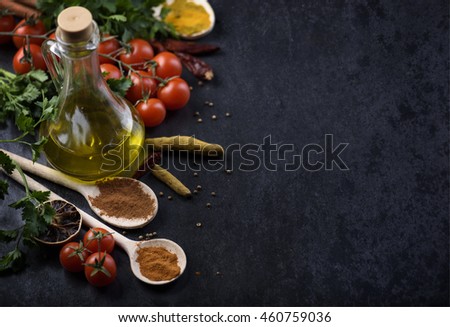 Various food ingredients and spices on rustic black background with copyspace.