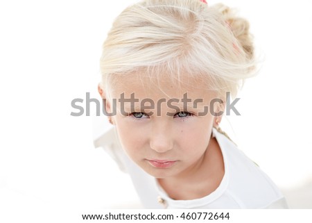 Portrait of beautiful little girl in a white dress near the columns