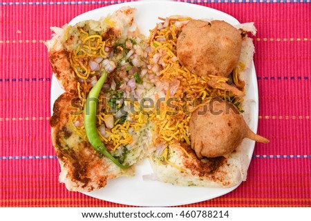 Vada Pav/paav usually served with tomato sauce, sweet/green chutney. Indian fast/street food snack, North India, Maharashtra. vada sandwiched between two slices/lloaf of bread.