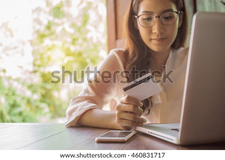 woman holding credit card on laptop for online shopping
