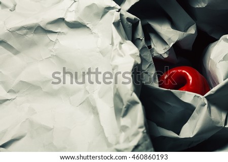 Symbolism concept. Red sweet pepper on gray crumpled paper background. Close up. Copy-space. Top view. Flat lay. Studio shot