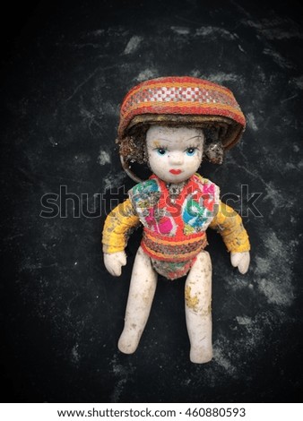 Old ethnic doll (Hill tribe) sitting on antique black pot
