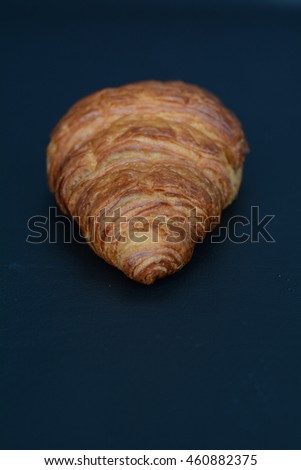 isolated croissant on a black table. croissant isolated on a black background. creative concept. healthy concept. 