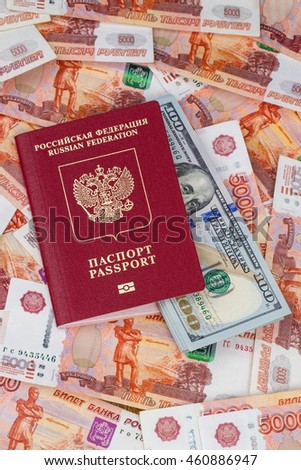 Russian passport for foreign countries with a bundle of one hundred dollar bills and 5,000 rubles isolated on a black background
