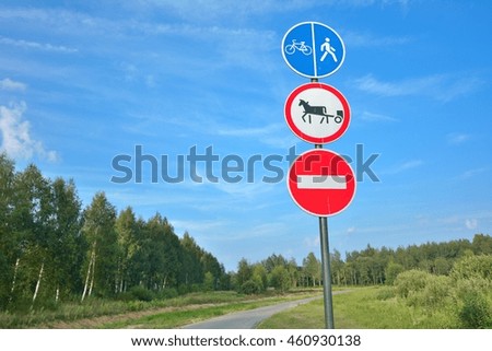 Serpentine road for pedestrians and cyclist in pine forest with signs stat that entry for cars and horse is forbidden.