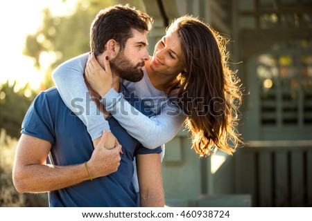 Two lovers in blue clothing in nature park outdoors hug and kiss Royalty-Free Stock Photo #460938724