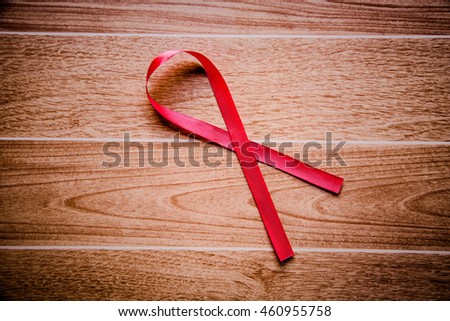 Red ribbon on wooden  background,AIDs awareness ,Health and medical concept