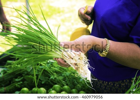 Fresh organic green vegetables source of vitamin in basket bamboo texture on wooden floor.