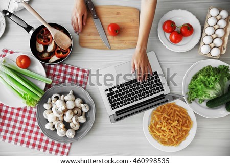 Woman cooking in kitchen. Food blog concept, top view Royalty-Free Stock Photo #460998535