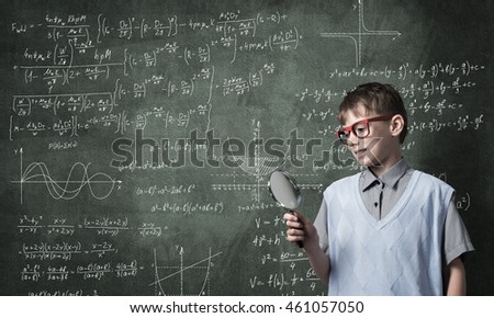 Curious school boy with magnifier