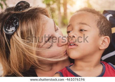 Happy mother kissing her little son. International family