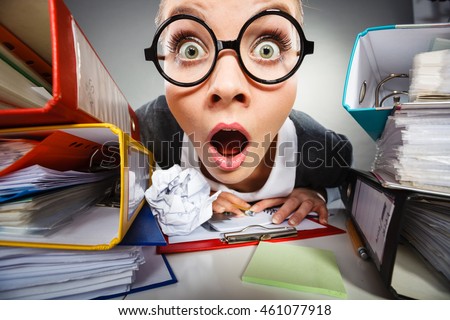 Facial expressions during work. Crazy thoughtful accountant businesswoman surrounded by documents and binders in office. Royalty-Free Stock Photo #461077918