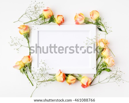 Frame with roses on white background. flat lay, overhead view.