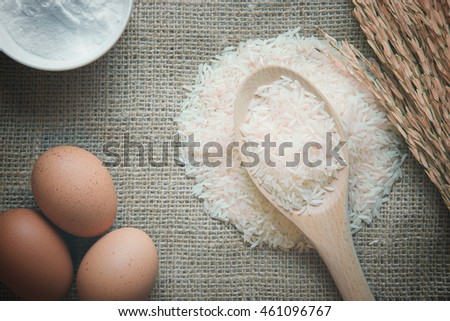 Rice in ladle with eggs and flour ingredient on burlap material background. top view. vintage color. Free space for text. Food background