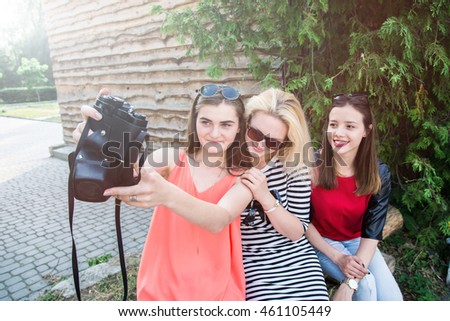 Best friends make selfie photo with old retro camera while traveling across Europe on vacation - Funny outdoor activity of young fashion students away from home - Vintage editing with soft vignette