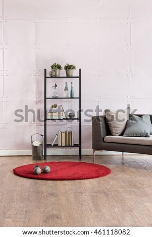 modern living room corner sofa behind stone soft wall and black lamp with red carpet