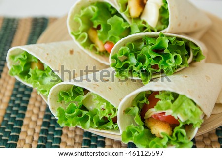 rolls fastfood.  chicken nuggets, lettuce, tomato, cheese, Mexican tortillas