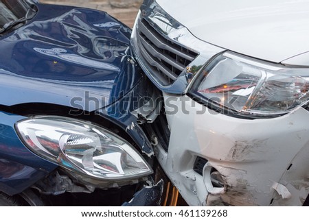 Car crash from car accident on the road in a city between saloon versus pickup wait insurance.