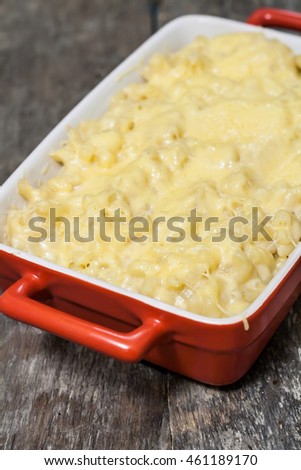 cheese pasta baked in a ceramic form on background wooden table.