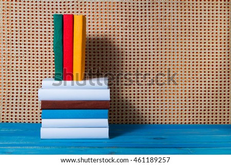 Stack of colorful books. Education orange rattan background. Back to school. Copy space for text