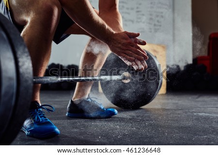 Closeup of weightlifter clapping hands before  barbell workout at the gym Royalty-Free Stock Photo #461236648