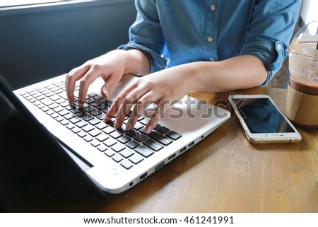 business woman hand multitasking using phone and working on laptop connecting wifi internet and coffee cup, businessman busy hardworking  using laptop at office wooden desk background