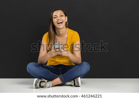 Beautiful woman sitting in the floor with her smarphone