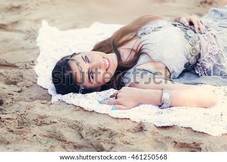 beautiful cheerful young woman with blue eyes lying on the beach view from the top