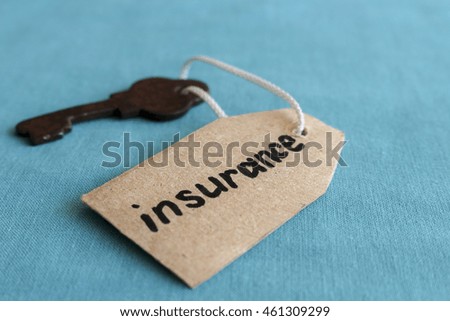 The concept of home insurance - the old key with the inscription on the tag , on the turquoise background.