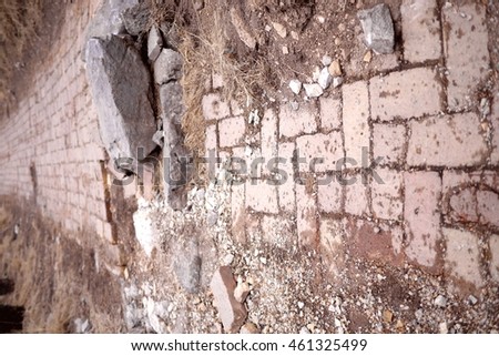 Photo of a mountain path covered with bricks with a large stone in the middle of it. Old broken road in the mountains. Obstacle in the way. Obstacle concept.