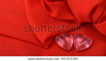 picture of a pink plastic heart on red canvas background. valentine's day celebration concept.