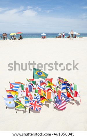 Brazilian flag surrounded by international flags flying on smooth sand at Ipanema Beach in Rio de Janeiro, Brazil