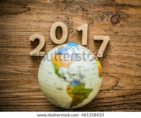 New year 2017 with round globe map lie on wooden table texture. Empty copy space for inscription or objects.