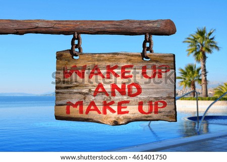 wake up and make up motivational phrase sign on old wood with blurred background