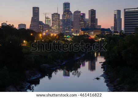 Dawn breaking behind the Houston, Texas skyline with Buffalo Bayou in the foreground.