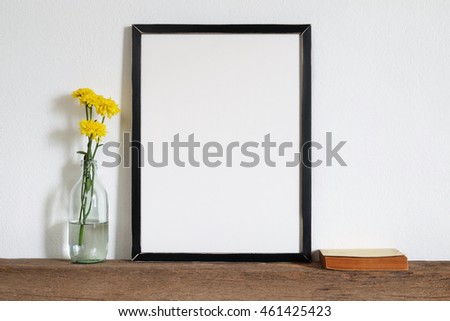 mock up of blank photo frame with yellow flower  wooden shelf.