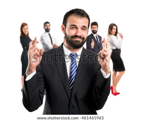 Young businessman with his fingers crossing with many people behind