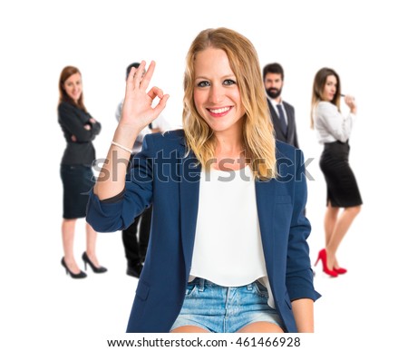 Woman making Ok sign with many people behind