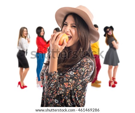 Pretty woman eating an apple with many people behind