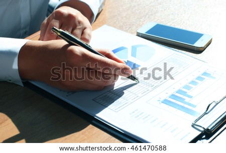 Close-up of graphs and charts analyzed by businesswoman 