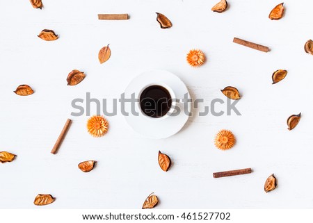 Autumn composition with cup of coffee, dried flowers, autumn leaves and cinnamon sticks. Top view, flat lay