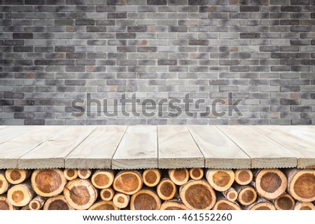 Empty top of wooden table or counter with pile wood log and stone wall background. Interior decoration for product display