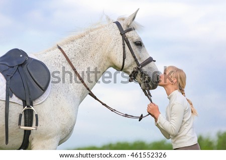 Girl kissing a horse.