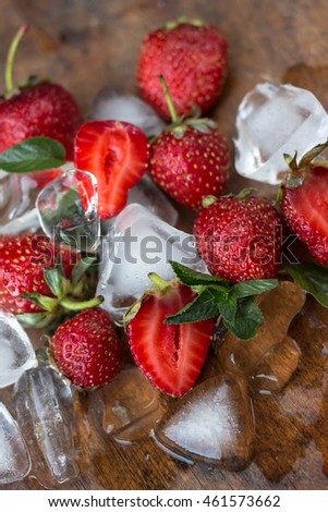 Fresh strawberries, mint leaves and ice  on the wooden background. vintage. close up