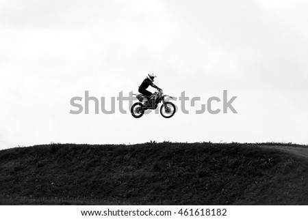 Motorbike jumping in the sky on hide speed black and white photo