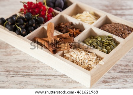mix of ingredients for a breakfast - oats, a seed, cinnamon and berries on a tray, selective focus