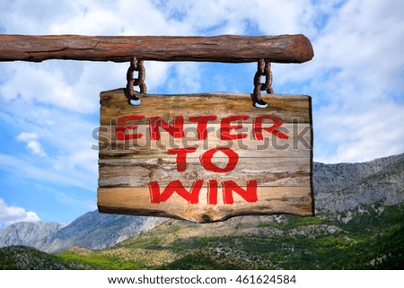 Enter to win motivational phrase sign on old wood with blurred background